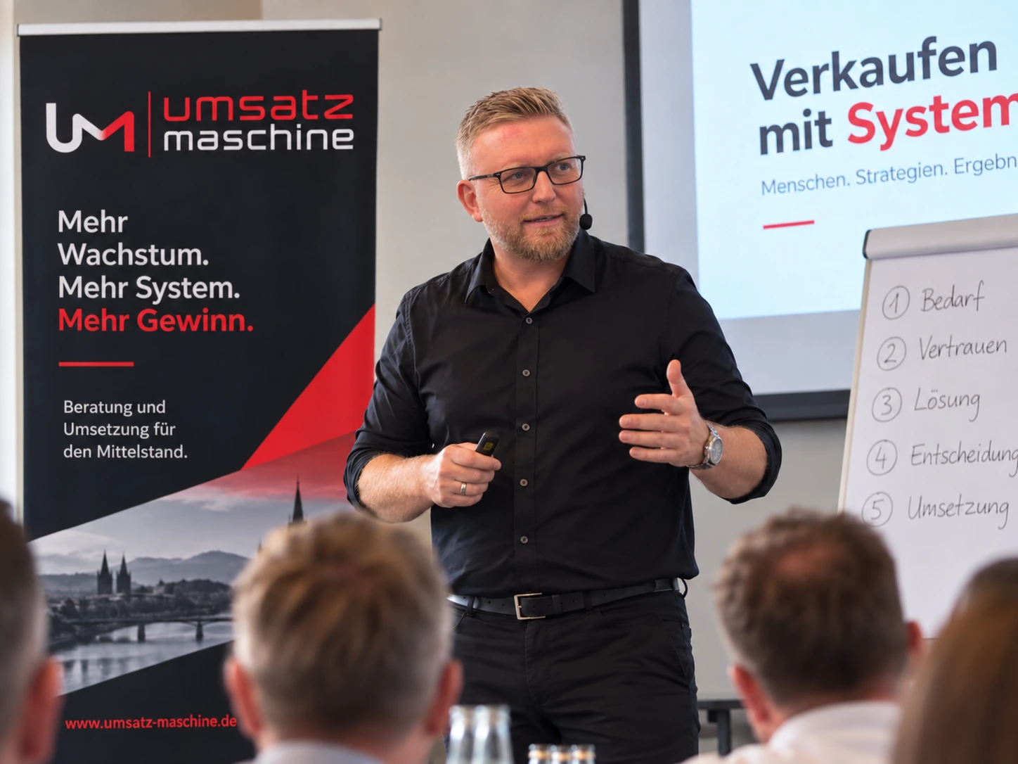Sascha Frenz im schwarzen Hemd beim Vertriebstraining mit Umsatzmaschine-Branding.